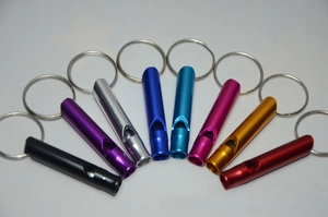 Close-up of lightweight aluminum survival whistles in eight bright anodized finishes