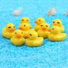 Close-up of yellow rubber ducks with different expressions on blue sand beach background