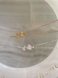 Macro detail of 925 sterling silver rose flower pendants in gold and silver finishes