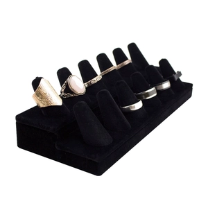 Three-tier black velvet jewelry display stand for showcasing fifteen rings on a white background