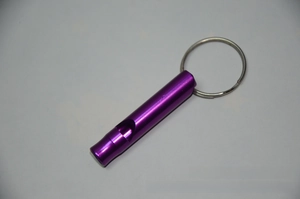 Detail of a purple anodized aluminum safety whistle with a metallic keychain ring