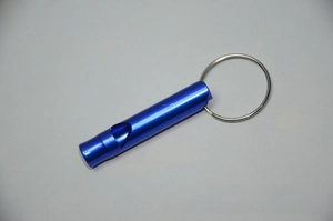 Close-up of blue aluminum survival whistle with a silver keychain ring for outdoor use