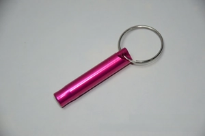Close-up of rose red aluminum survival whistle with a silver keychain ring attached