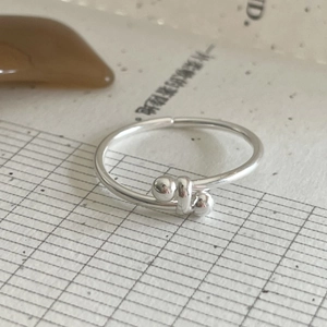 Minimalist 925 sterling silver open ring with dual bead wrap design on textured background