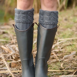 Deep grey rain boots with chunky knit cable pattern leg warmers on outdoor grass