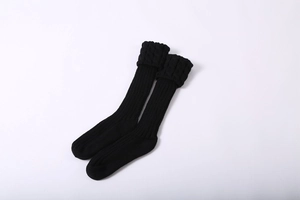 Detail of black cable knit leg warmers with thick ribbed texture and turnover cuffs