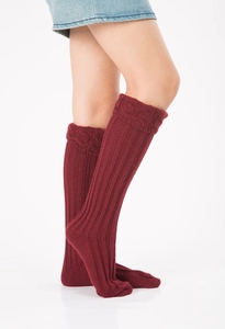 Close-up of burgundy cable knit leg warmers showing ribbed texture and crochet details