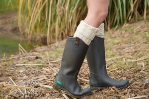 Detail of grey matte rain boots with cozy cable-knit leg warmers in an outdoor setting