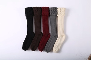 Close-up of cable knit leg warmers in black, brown, burgundy, gray and beige colors