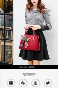Close-up of red PU leather handbag with geometric stitching, gold metal clasp and fur pompom