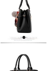 Side view of black leather handbag with grey faux fur pompom and floral silk scarf