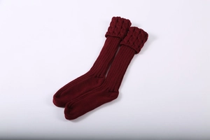 Detailed close-up of wine red knitted leg warmers with thick cable stitch and ribbing