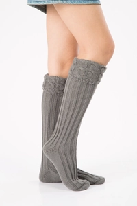 Detail of grey cable knit leg warmers with textured ribbing and decorative twist pattern