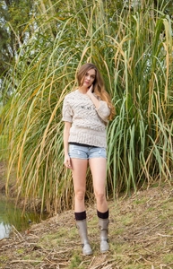 Detailed cable knit texture of beige short-sleeve sweater on model in natural setting