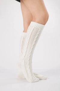 Close-up of cable knit texture on cream leg warmers with ribbed cuffs for winter