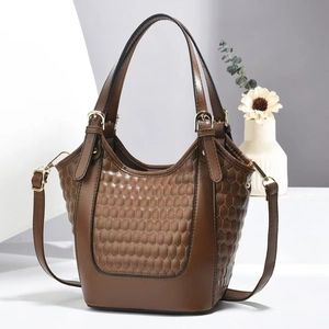 Détail du sac à main marron avec texture matelassée hexagonale et finitions dorées