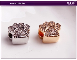Macro shot of silver and gold animal paw charms with white cubic zirconia stones
