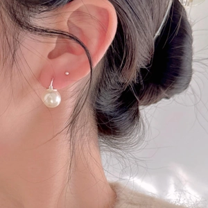 Minimalist 925 sterling silver earring with large white pearl drop on model ear