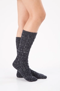 Detail of dark grey knit Christmas cabin socks with thick cable stitch and ribbed cuffs