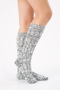 Macro detail of thick cable-knit texture on charcoal grey mid-calf wool socks
