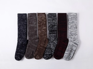 Detail of six colorful chunky knit winter socks displayed in a horizontal row on white