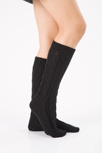 Close-up of black cable knit leg warmers with detailed braided texture and elastic fit