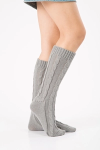 Detail of grey cable knit leg warmers showing thick braided texture and over-knee length