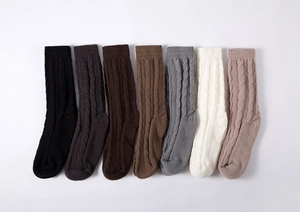 Detailed flat lay of cable knit leg warmers in seven colors on a white background