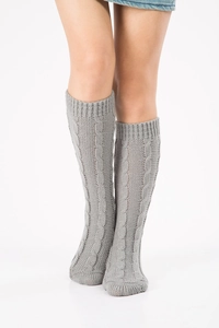 Detailed close-up of grey cable-knit leg warmers with ribbed cuffs on white background