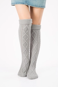 Detailed view of grey cable-knit over-knee leg warmers with thick winter texture