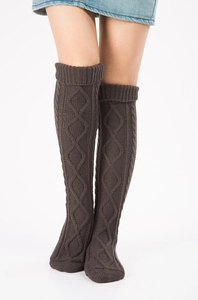 Close-up of dark brown cable knit leg warmers with classic diamond pattern texture