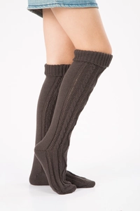 Detailed cable knit texture of dark brown thigh-high leg warmers for autumn and winter