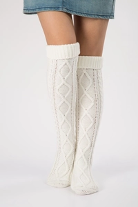 Detailed view of white cable-knit over-knee leg warmers showing soft wool texture
