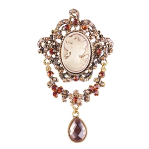 Detailed view of a vintage gold brooch with cameo center and amber rhinestones