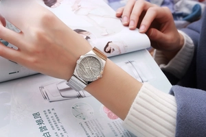Close-up of a luxury silver quartz watch with diamond dial worn on a female wrist