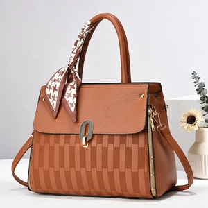 Dettaglio borsa a mano marrone con trama pied-de-poule e accessorio foulard in seta decorativo