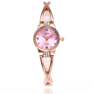 Dettaglio dell'orologio al quarzo in oro rosa con cinturino a incrocio e strass