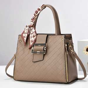 Sac à main minimaliste en cuir beige texturé avec motif matelassé et poignée en soie