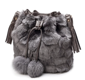 Chic grey faux fur drawstring bucket bag with plush pom-pom charms and leather fringe