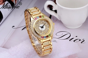 Close-up of luxury gold ladies watch with colorful rhinestones and sparkling crystal dial
