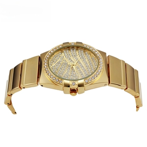 Macro detail of luxury gold-tone watch face featuring full diamond-encrusted bezel