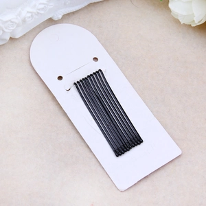 Professional black metal hair clips on white card set against marble background
