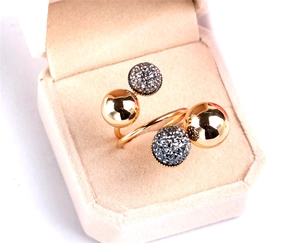 Detail of rose gold brass ring with polished beads and sparkling grey crystals