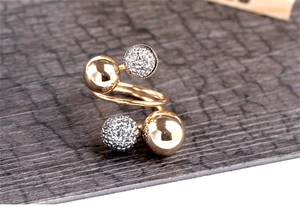 Detailed macro view of spiral gold ring with polished beads and crystal pavé spheres