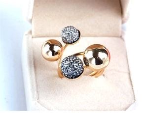 Detailed view of a gold-plated brass ring featuring polished beads and pavé crystal settings