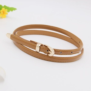 Detailed view of a brown leather skinny belt featuring a classic gold metal buckle