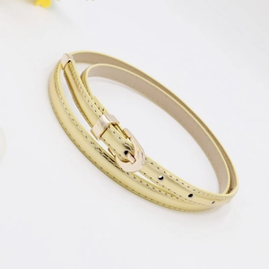 Detail view of a slim gold leather belt featuring a polished gold metallic buckle