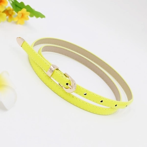 Detailed view of a slim yellow leather belt with a golden metal buckle for women