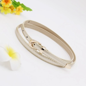 Detail view of a slim beige faux leather belt for women with elegant golden metal buckle