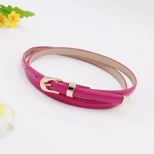Detail of rose red skinny leather belt with gold metal buckle and tip on white background